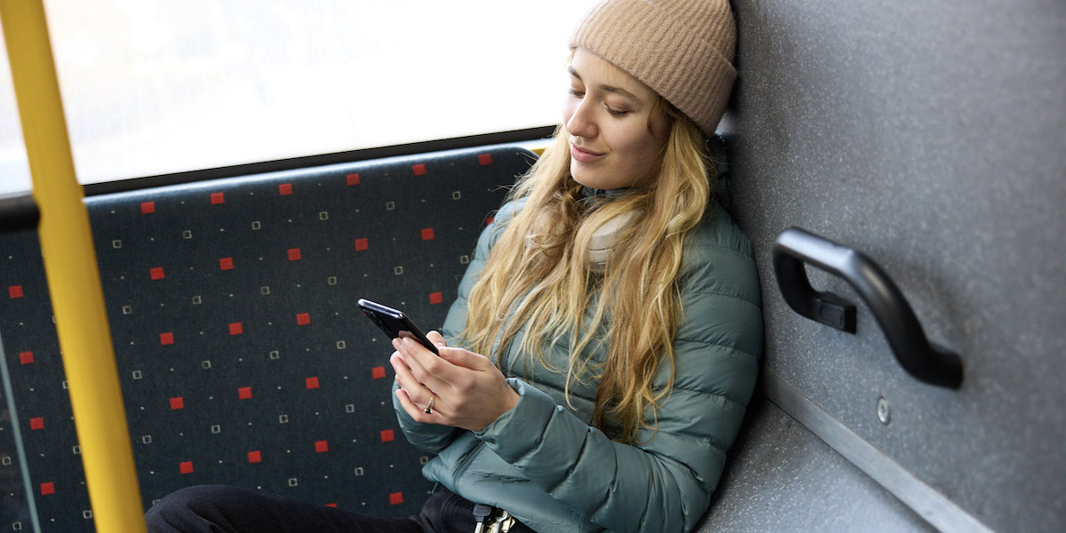 Smilende dame med mobil setter pris på ubrukt mobildata