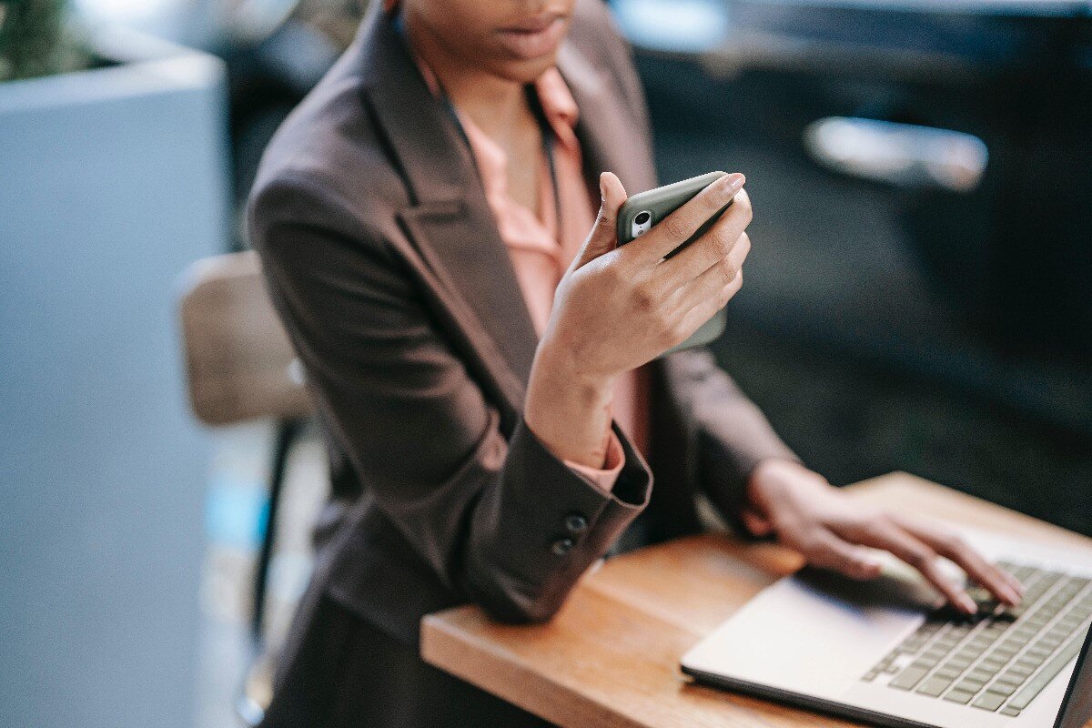 Kvinne som opplever svindel via både mobilen og laptopen