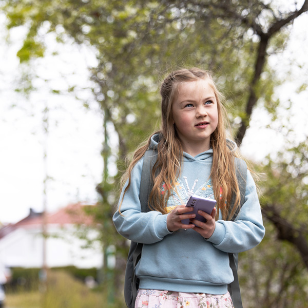 Skolejente som bruker mobilen med abonnement fra Telenor